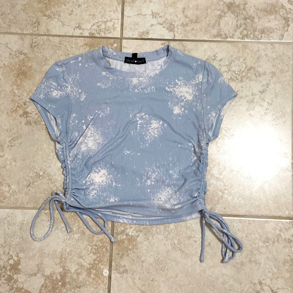 Light blue top with splashes of white and adjustable ties on the sides